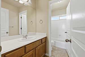 Bathroom with vanity, light tile patterned floors, and bathing tub / shower combination