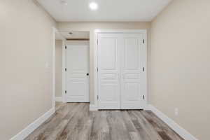 Unfurnished bedroom with light wood-style flooring and a closet