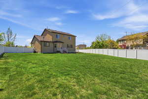 Back of house featuring a fenced backyard and stucco siding
