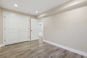 Unfurnished bedroom with light wood-type flooring, a closet, and recessed lighting