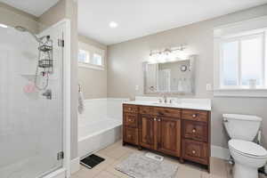 Full bathroom with vanity, light tile patterned floors, a shower stall, and a bath