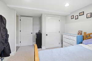 Bedroom with light colored carpet and a closet