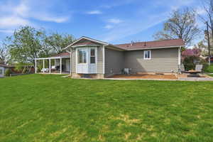 Rear view of house featuring a patio area and a yard