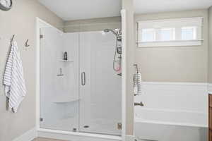 Bathroom featuring vanity, a bath, and a shower stall
