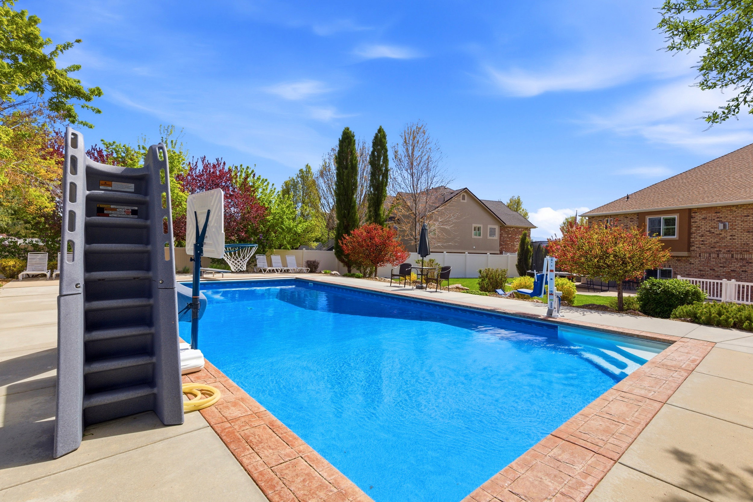 View of swimming pool featuring patio surround, a fenced backyard, and a residential view
