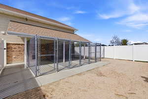Back of property with an exterior structure, brick siding, an outbuilding, roof with shingles, and a gate