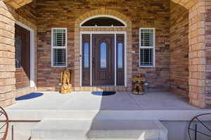 Doorway to property with a porch and stone siding