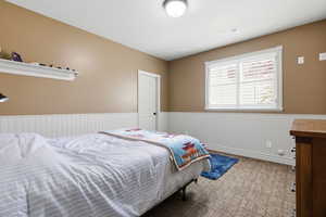 Bedroom featuring carpet floors and a wainscoted wall