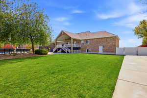 Rear view of property with a gate, brick siding, a patio, and roof with shingles