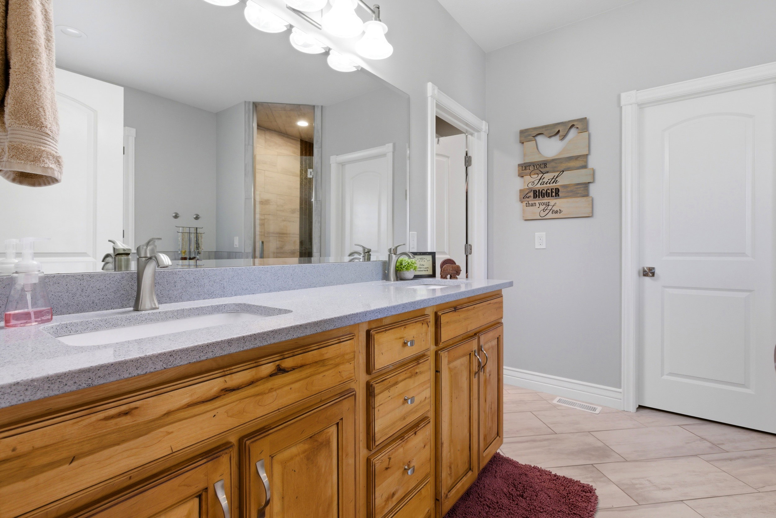 Bathroom featuring double vanity and a stall shower