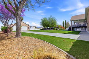 View of yard featuring a garage, concrete driveway, and a residential view