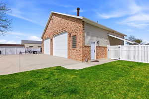 View of home's exterior featuring a gate, brick siding, and a detached garage