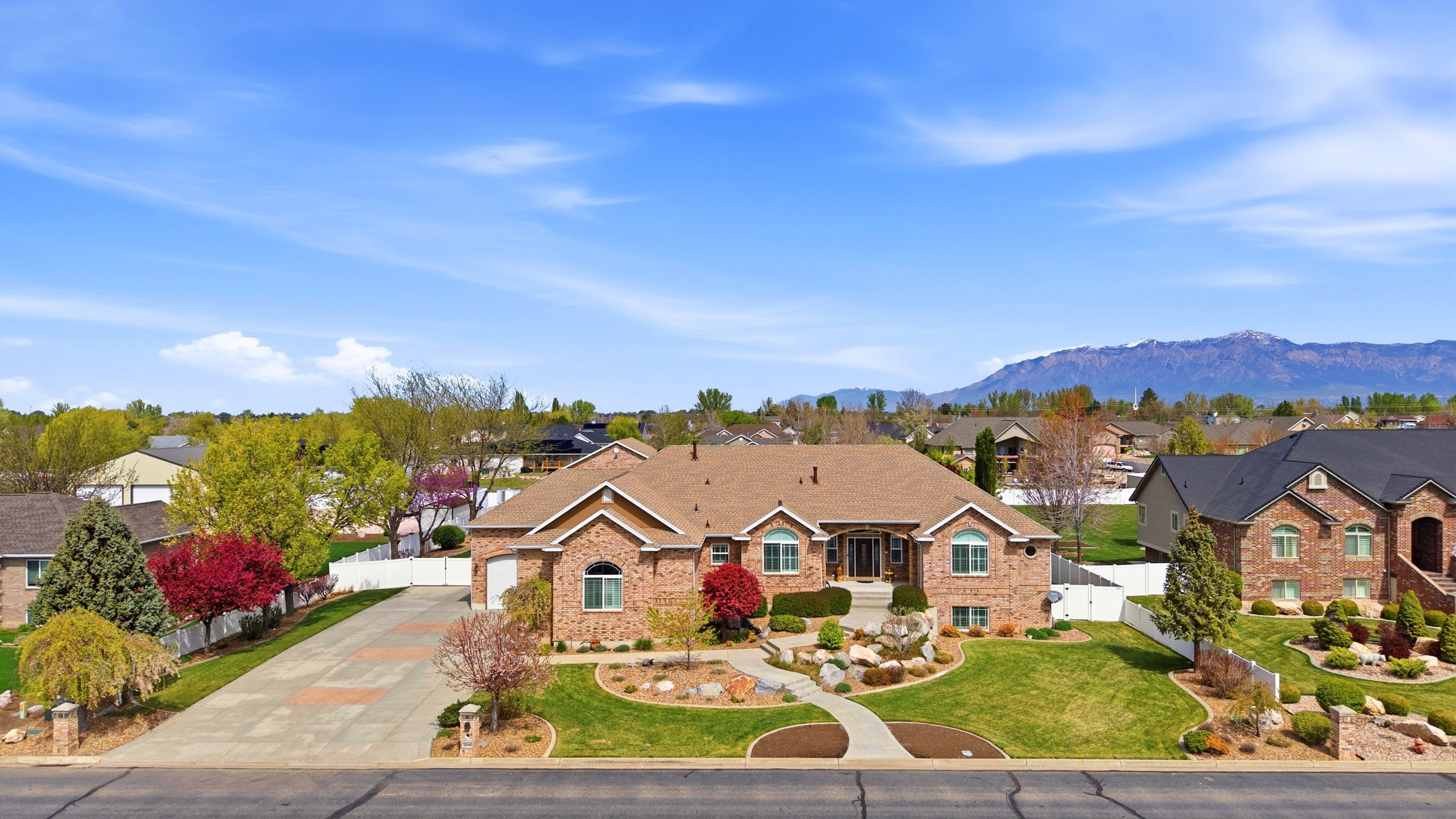 Ranch-style home with a residential view, brick siding, driveway, a gate, and a mountain view