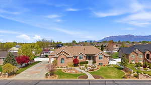 Ranch-style home with a residential view, brick siding, driveway, a gate, and a mountain view
