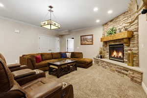 Living room featuring crown molding, carpet, a fireplace, and recessed lighting