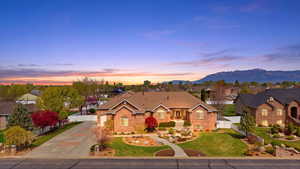 View of front facade with concrete driveway, brick siding, a residential view, and a gate