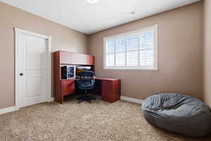 Office space with light carpet and baseboards