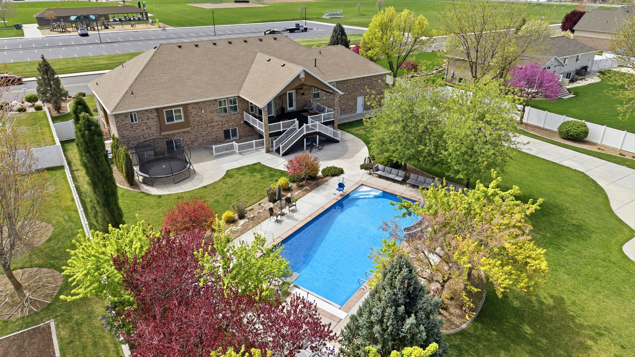 Aerial view of property and surrounding area featuring a golf club and a pool area