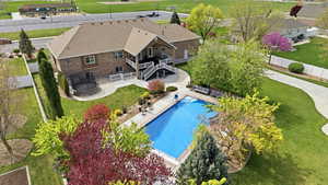 Aerial view of property and surrounding area featuring a golf club and a pool area
