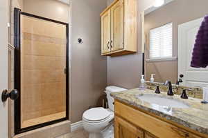 Bathroom with a stall shower, vanity, and light tile patterned flooring