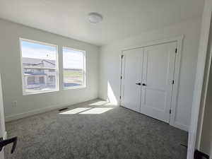 Unfurnished bedroom with carpet flooring and a closet