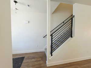 Staircase with baseboards and wood finished floors