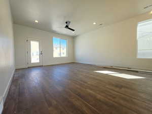 Empty room with a ceiling fan, dark wood-style flooring, and recessed lighting