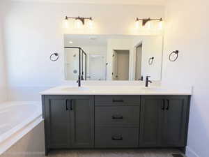 Full bath featuring double vanity, a stall shower, and a garden tub