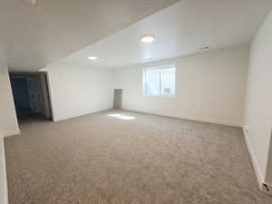 Unfurnished room with light carpet and a textured ceiling