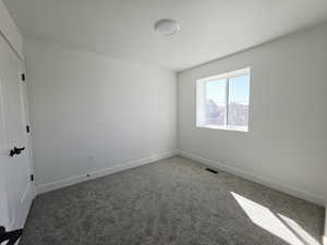 Unfurnished room with dark colored carpet and a textured ceiling