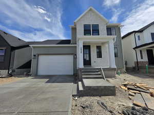 View of front facade featuring brick siding, concrete driveway, a garage, and a porch