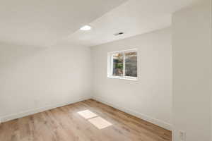 Spare room with light wood-style floors and baseboards