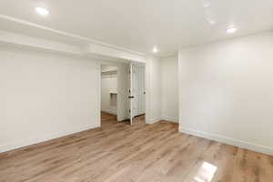 Finished basement featuring light wood finished floors and recessed lighting