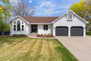 Single story home featuring brick siding, driveway, a front lawn, a porch, and a garage