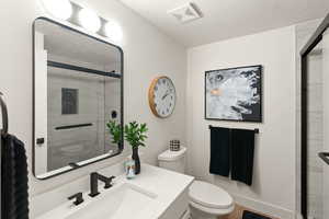Full bathroom featuring vanity, a textured ceiling, and a shower stall