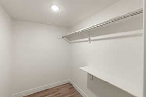 Walk in closet with light wood-style floors