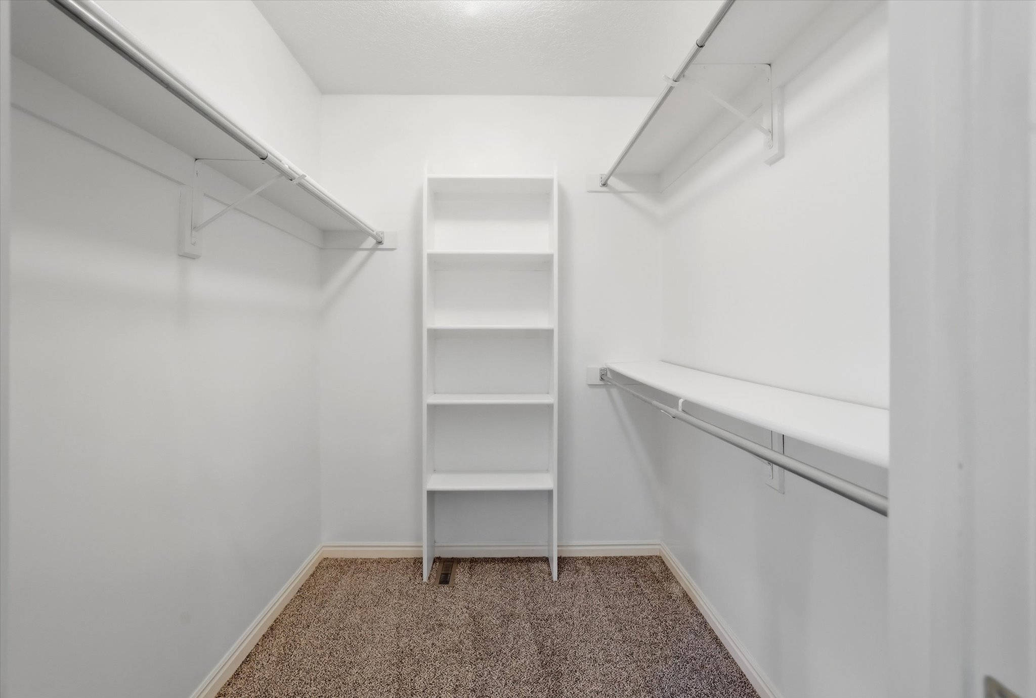 Walk in closet with shelves and clothing space