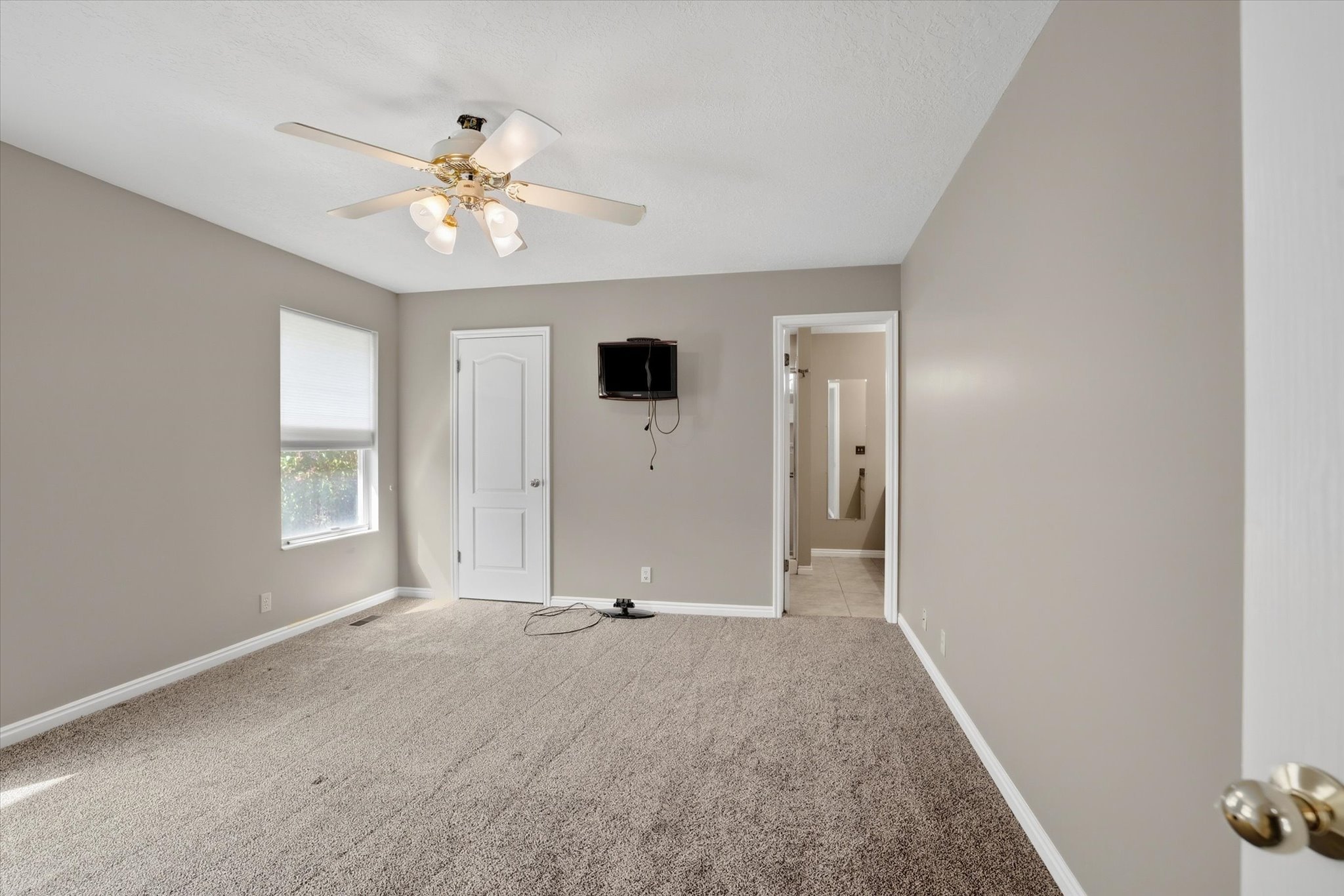 Primary bedroom with ceiling fan and private bathroom