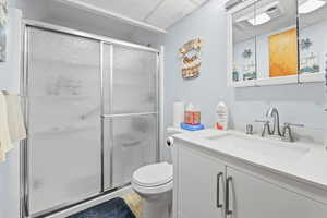 Bathroom with vanity, a stall shower, and light wood finished floors
