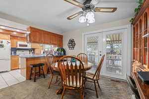 Dining room featuring light tile patterned floors, ceiling fan, light carpet, french doors, and recessed lighting