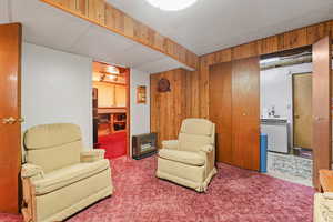Sitting room featuring wood walls and carpet floors