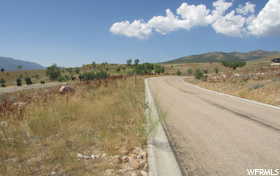 View of asphalt street with a view of countryside and a mountain view