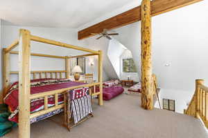Carpeted bedroom featuring lofted ceiling with beams and ceiling fan