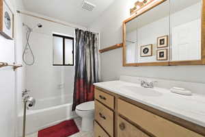 Bathroom featuring vanity, shower / bath combination with curtain, and light flooring