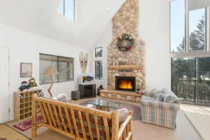 Living area with a stone fireplace and lofted ceiling