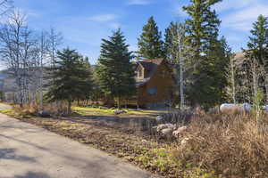 View of side of property featuring a wooden deck
