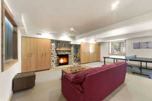 Living room with light colored carpet, a fireplace, and recessed lighting