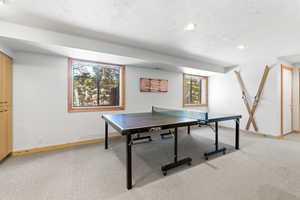 Game room with light colored carpet, a textured ceiling, and recessed lighting