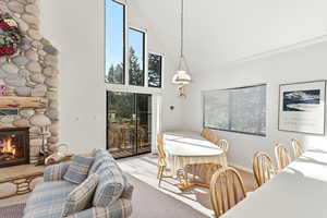 Dining room with vaulted ceiling, a fireplace, and light carpet