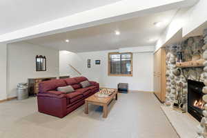 Living room with a fireplace, light carpet, and recessed lighting